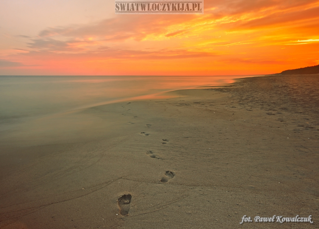 Footprints on the sea beach during sunrise